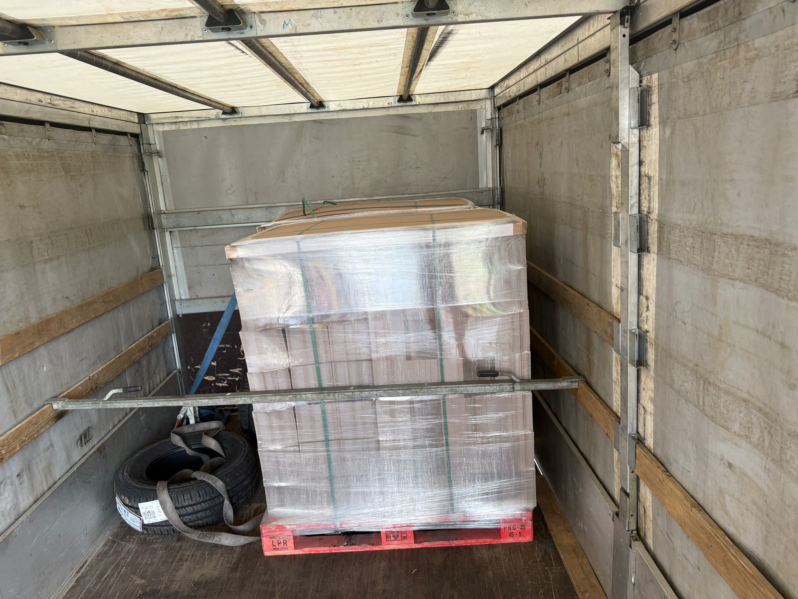 Heavy wooden cable reels loaded and lashed inside the trailer